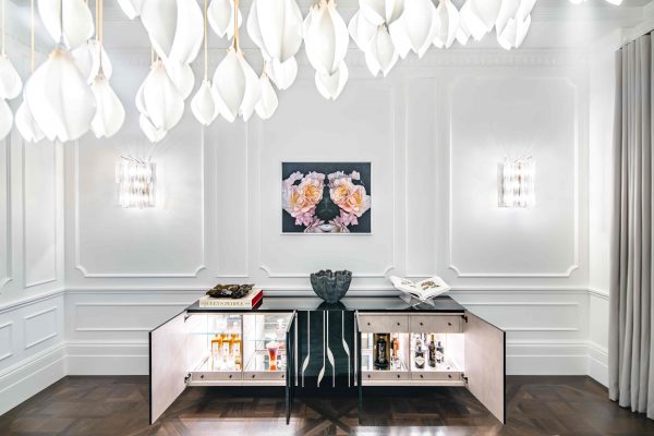 Modern cocktail cabinets with a vase centrepiece and and drinks on display.