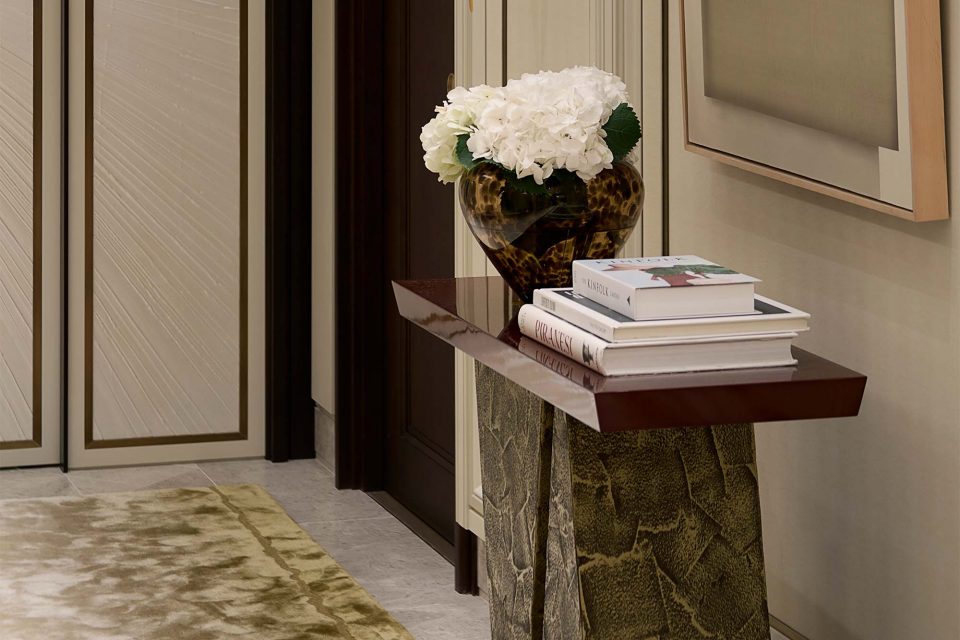 Elegant Hallway that features a console table with a red top and bronze base - A Serene and Artisanal Luxury Home in Mayfair