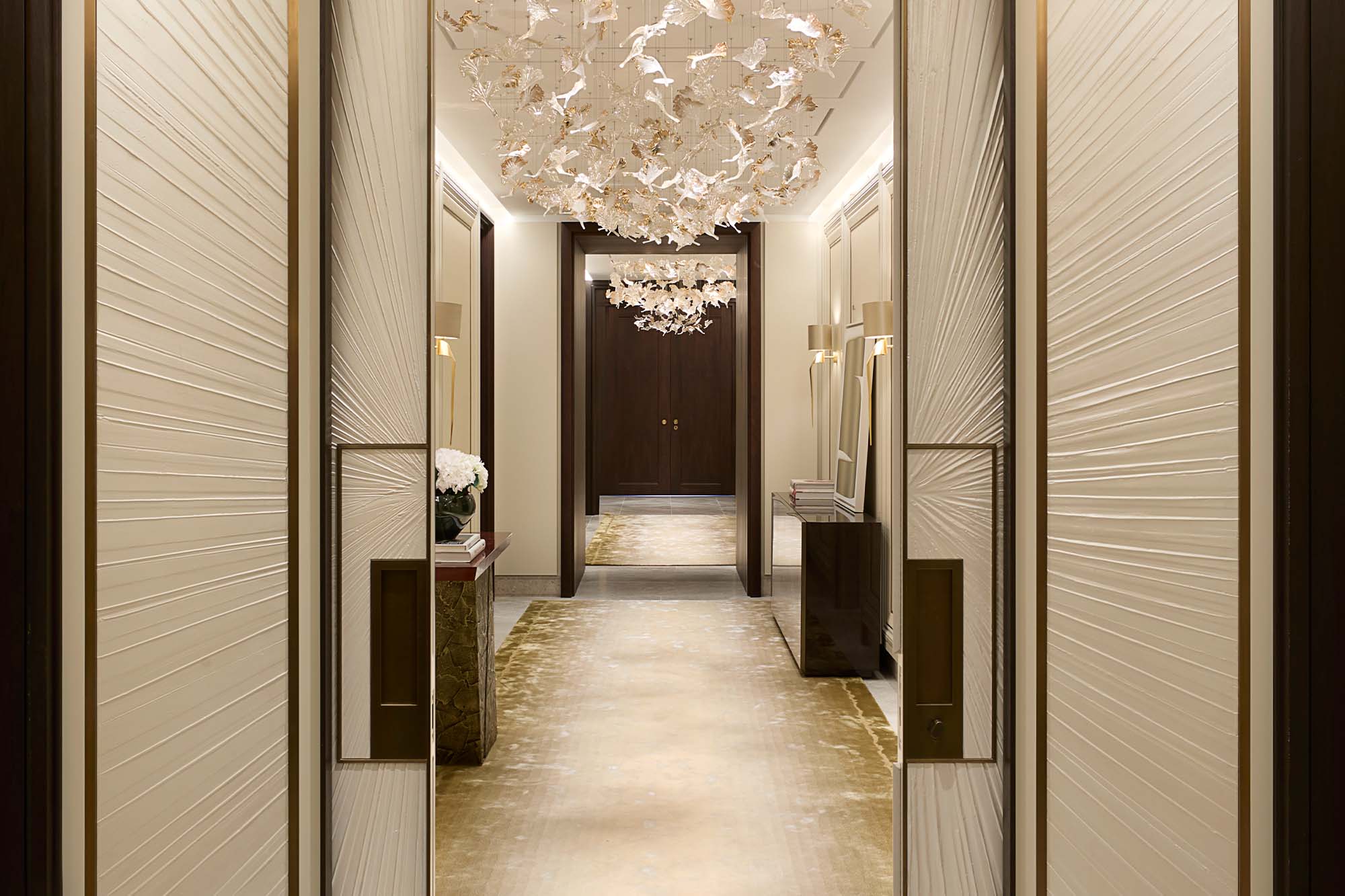 Elegant Hallway that features a console table with a red top and bronze base, and a sideboard with sycamore black casing and sycamore pearl doors - A Serene and Artisanal Luxury Home in Mayfair